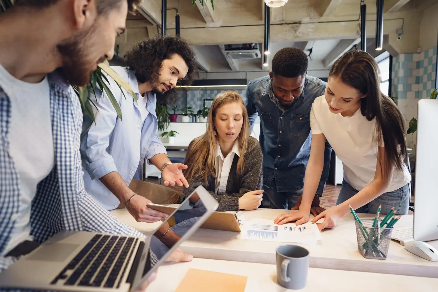 Plusieurs collaborateurs réunis autour d'une table lors d'une réunion d'équipe en entreprise